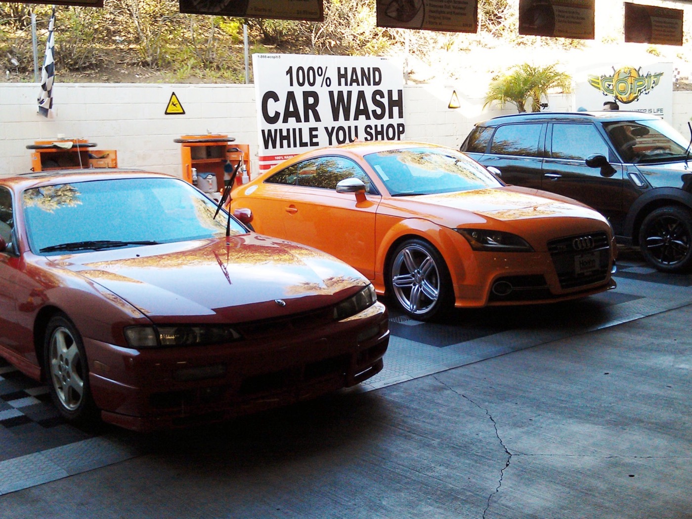Classic cars lined up at the Green Go Wash wall